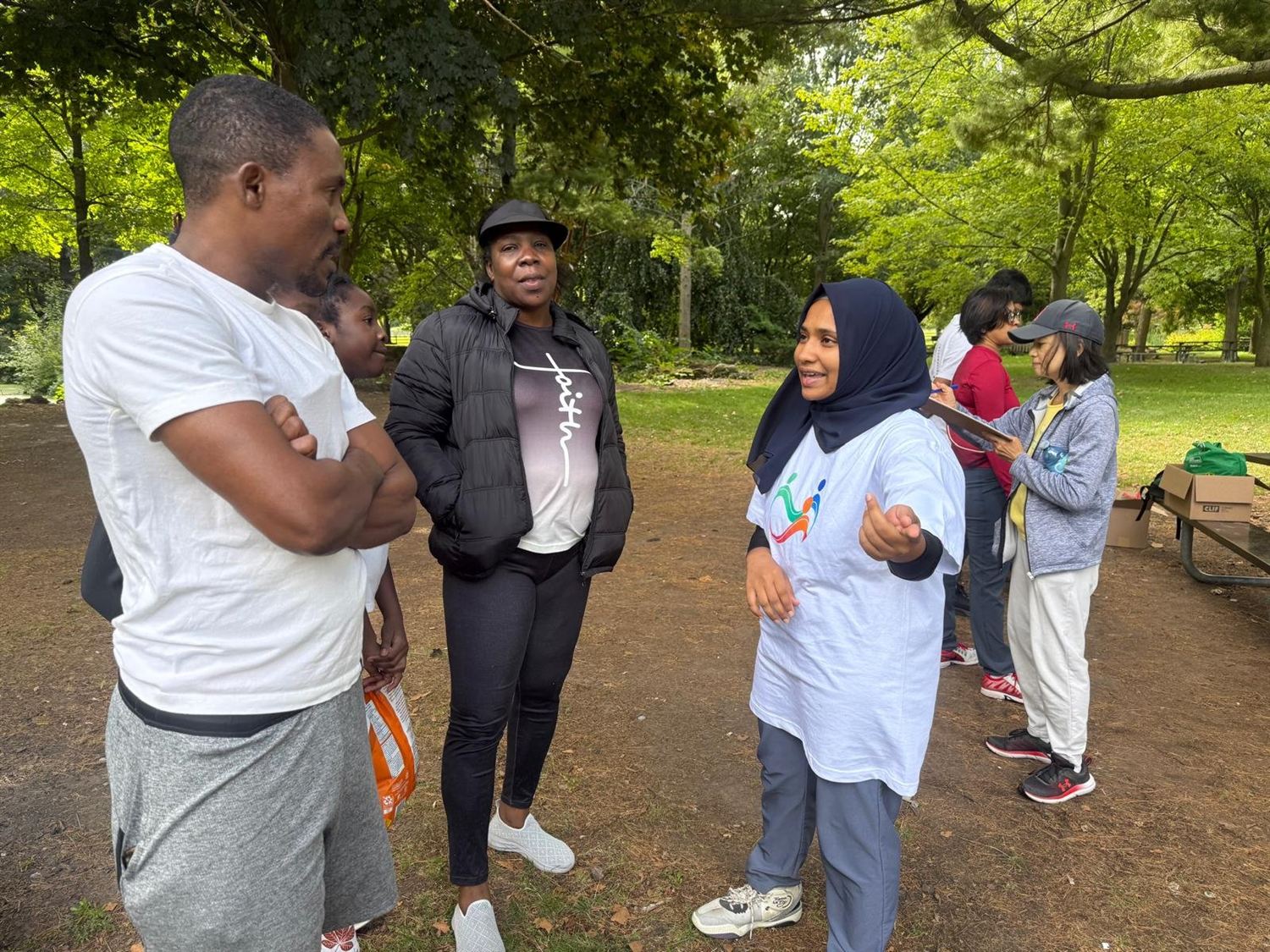 WakeUp Health team members talking with community members at an outdoor park programme